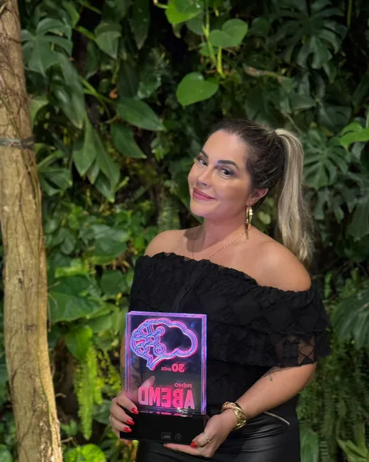 Paula Abou segurando o troféu do Prêmio ABEMD